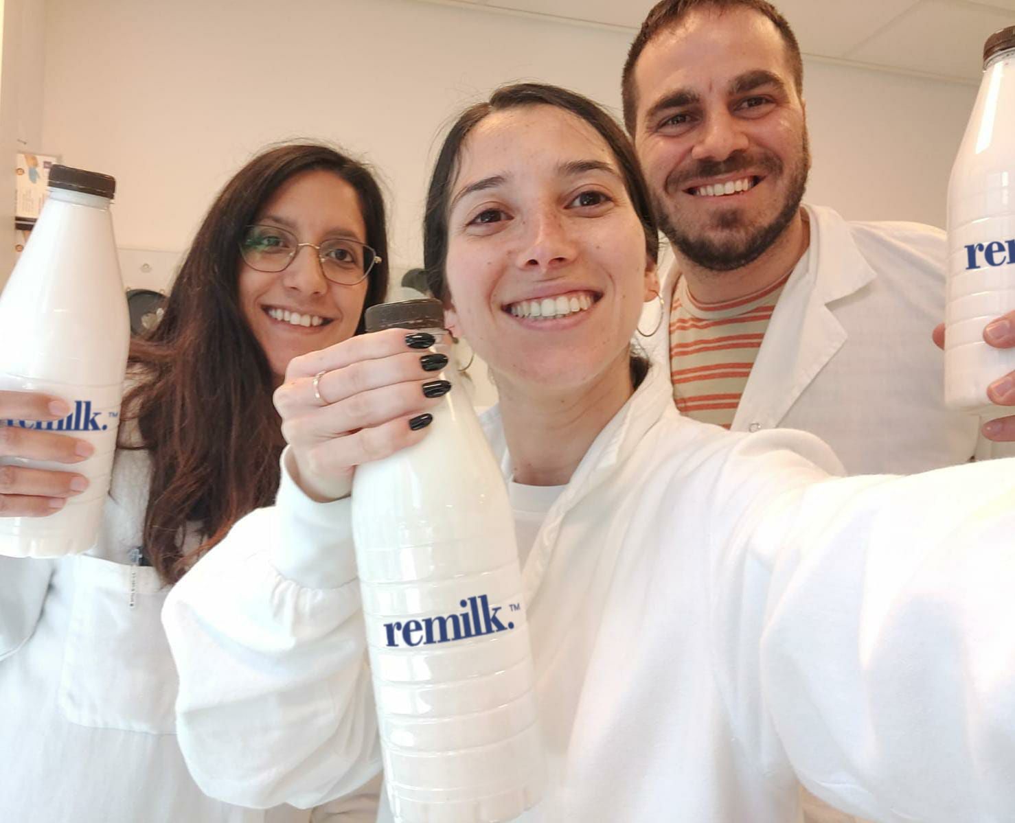 A picture of Remilk employees holding the bottles with milk